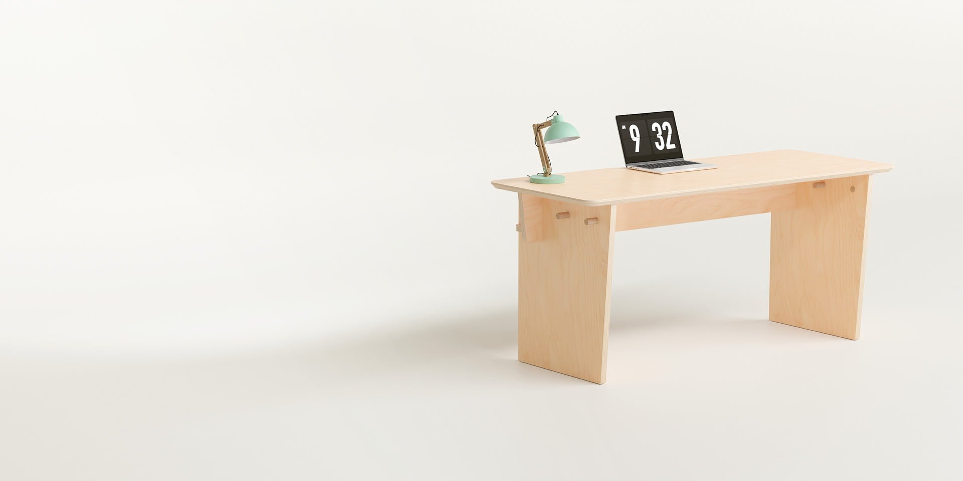 The Ecosium Studio desk made from sustainable timber in Australia sitting on a white background with a green desk lamp and an Apple laptop