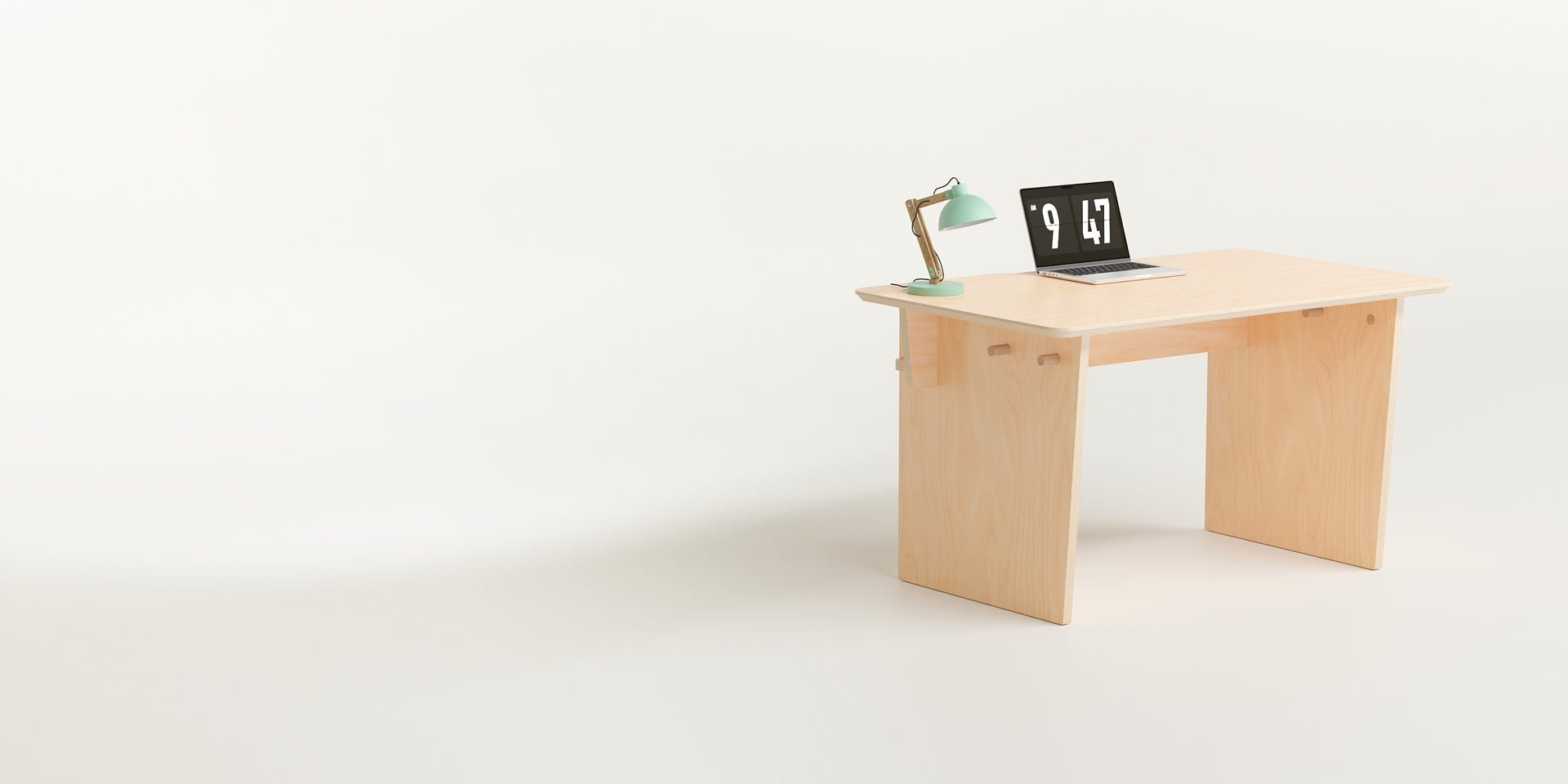 The Ecosium Stubby desk made from sustainable timber in Australia sitting on a white background with a green desk lamp and an Apple laptop