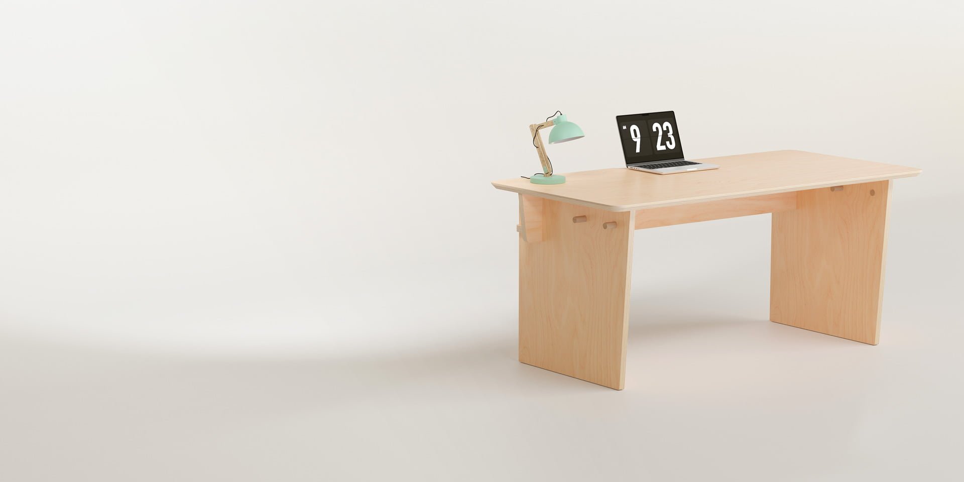 The Ecosium Big desk made from sustainable timber in Australia sitting on a white background with a green desk lamp and an Apple laptop
