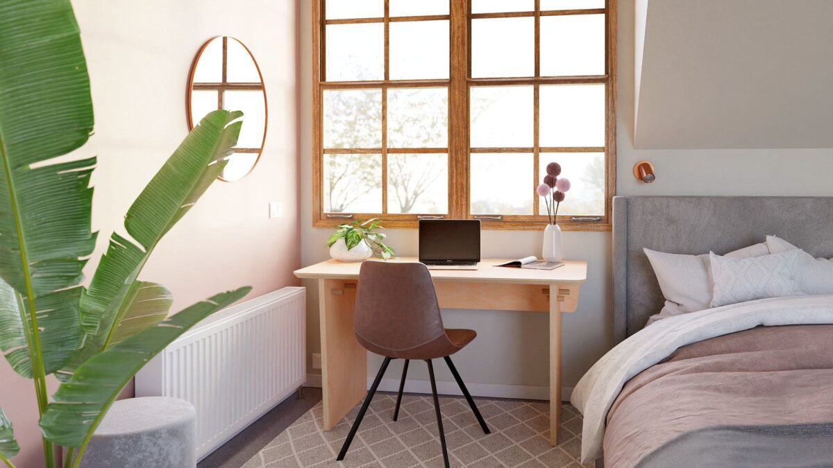 The sustainable Australian made Small Desk by Ecosium nestled beside a bed and looking out a big timber frame window in an upstairs loft style bedroom wide view